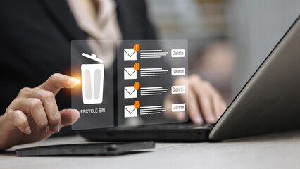 Businessman Deleting Spam Emails with Recycle Bin Icon on Laptop Computer