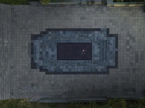 Aerial view of the eternal flame flickering against the dark stone of the Armenian Genocide memorial complex, Yerevan, Yerevan, Armenia.