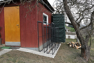 Red wooden house with choped wood for heating in the winter