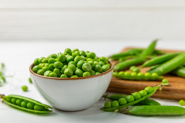 Fresh green pea pods with green peas on a wooden background. Sweet green peas. Green pea beans vegetables. Vegan. healthy vegetable. Copy space
