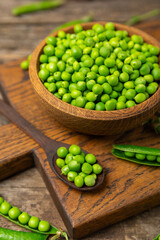 Fresh green pea pods with green peas on a wooden background. Sweet green peas. Green pea beans vegetables. Vegan. healthy vegetable. Copy space