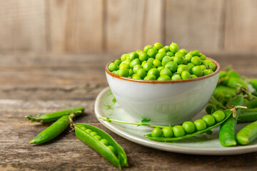 Fresh green pea pods with green peas on a wooden background. Sweet green peas. Green pea beans vegetables. Vegan. healthy vegetable. Copy space