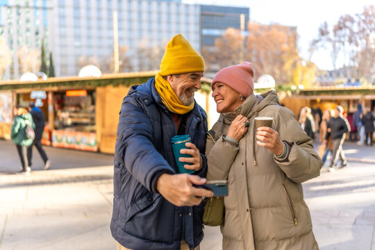 Happy senior couple taking a selfie at christmas market
