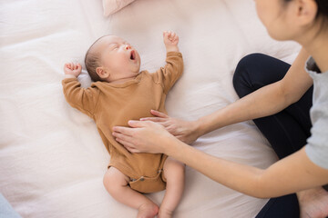 Newborn baby receiving gentle tummy massage from mother
