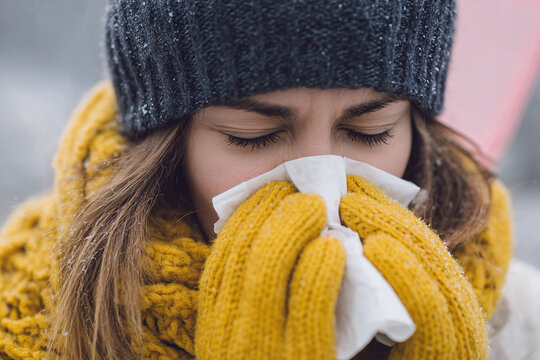 sick woman blowing her nose