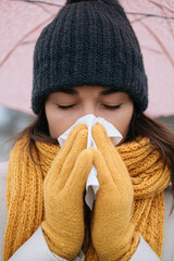 sick woman blowing her nose