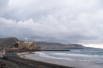 A cloudy day with a lighthouse Alfredo Kraus in the background. The beach is empty and the ocean is...