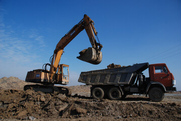 Obraz premium Heavy construction machines actively working on a building site. Excavators, bulldozers, and other equipment move soil and materials, symbolizing progress, development, and modern infrastructure.