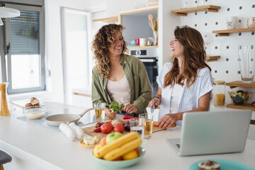 Young Women Friends Cooking Together in a Bright Modern Kitchen Using Fresh Ingredients