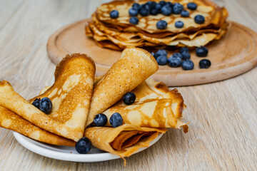 Sweet morning delight: thin crepes with blueberries and sugar powder