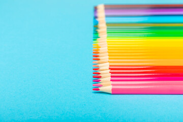 Colored pencils on a bright colored background. Equipment for coloring. Stationery for...