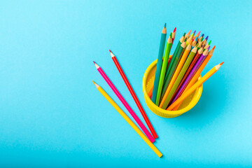 Colored pencils on a bright colored background. Equipment for coloring. Stationery for...