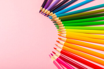 Colored pencils on a bright colored background. Equipment for coloring. Stationery for...