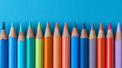Row of sharpened colorful pencils on pastel blue background for art, creativity, education, school supplies, and design inspiration