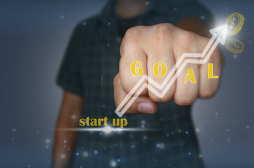 A businessman’s fist emphasizes determination and success, with the word “GOAL” and an upward...