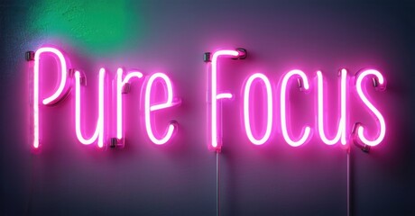 Bright pink neon sign displays words Pure Focus against purple, green wall. Dramatic lighting creates strong visual impact.