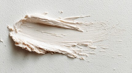 Close-up of a textured smear of white cream or lotion on a light in a minimalistic setting