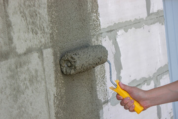 Worker Applying Plaster with Roller