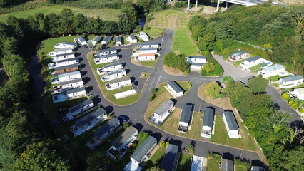 Aerial panorama of holiday park with caravans, chalets, and coastline – versatile for tourism,...