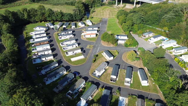 Aerial panorama of holiday park with caravans, chalets, and coastline – versatile for tourism, leisure, and vacation projects.