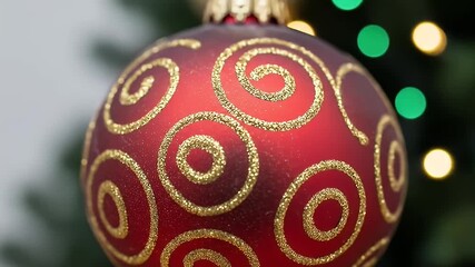 Macro view of a red Christmas ornament with spiraling golden glitter embellishments