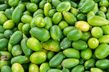 Pile of Fresh Green Limes A Vibrant Citrus Bounty. Fresh green limes are small, sour citrus fruits, bright green and firm with smooth skin, that are rich in vitamin C and antioxidants.