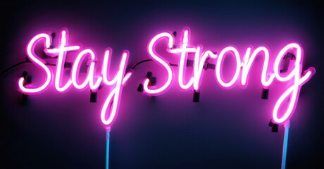 Bright pink neon sign displays Stay Strong. Dark background enhances glowing script. Positive message, simple design, vibrant colors present.