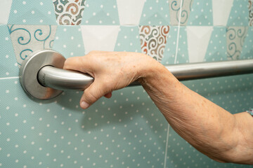 Asian elderly woman patient use toilet bathroom handle security in nursing hospital, healthy strong...