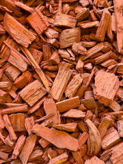 Red wood chips arranged as mulch creating a rough surface texture for landscaping and decoration....