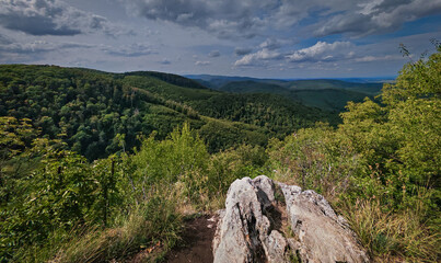 Wide view from Gulicska-tető, overlooking forested ridges and valleys of the Bükk Mountains under a dramatic sky.