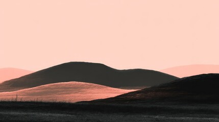 A silhouetted landscape dominates the frame, featuring rolling hills bathed in the warm glow of a dusky sunset. The foreground is dark,