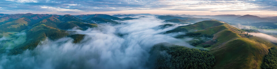 Obraz premium Panorama landscape with mountains in fog. Wide panoramic background with mysterious hills in morning in summer