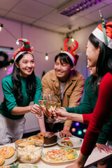 Friends toasting with wine at Christmas dinner party