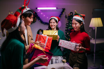 Friends exchanging gifts during Christmas party at home