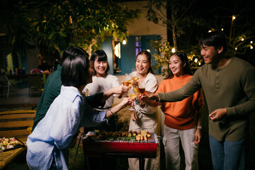 Friends toasting wine glasses at barbecue backyard party