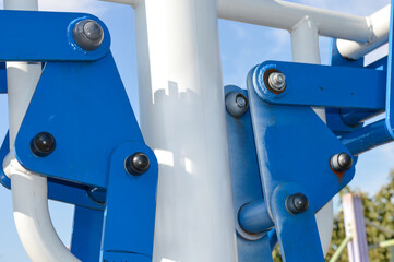 Close-up of blue industrial metal joints with bolts. Perfect for engineering, manufacturing,...