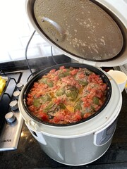 Electric rice cooker with cooked stuffed peppers and beef on kitchen counter