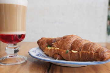 Delicious croissant and layered coffee at a cozy cafe
