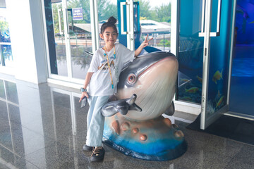 Child Posing with Whale Sculpture at Aquarium
