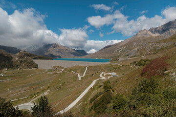 Scenic mountain lake surrounded by peaks with winding paths and alpine buildings