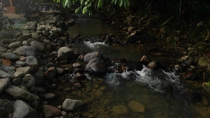 Scenic river with flowing water, rocks, trees, underwater view and sun reflection