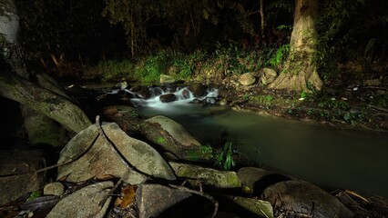 Scenic river with flowing water, rocks, trees, underwater view and sun reflection