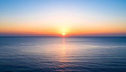 Obraz premium Serene ocean sunset with vibrant colors reflecting on the calm water.