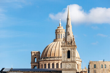 Obraz premium Closeup of the dome and spire of the Basilica of Our Lady of Mount Carmel in Valletta, Malta, set against a clear blue sky