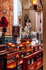Birgu, Malta – April 11, 2025: Interior of St Lawrence Collegiate Church decorated for Holy Week, with religious statues, candles, and ornate marble architecture in a historic Maltese sanctuary.