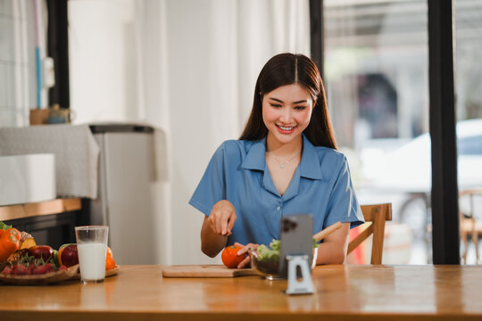 Food blogger preparing healthy salad and recording video with smartphone