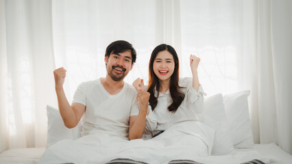 Happy Couple Celebrating Success in Bed