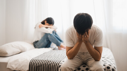 Young couple arguing and feeling frustrated on bed in bedroom