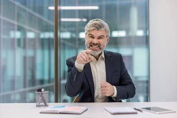 Angry businessman pointing aggressively in a modern office environment