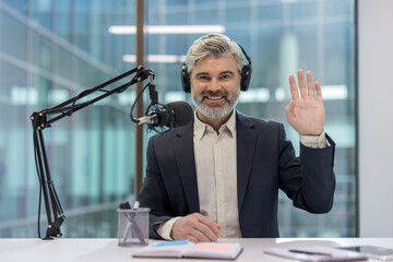 Professional host speaking into a microphone during a podcast recording session.